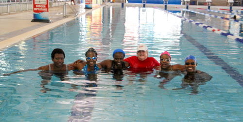 Multicultural women in the pool with their instructor