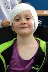 A young girl with her head bandaged up