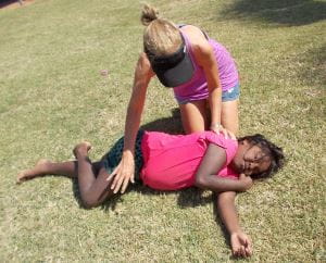 Leisa putting an aboriginal girl in the recovery position