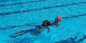 Liesa in the water with an aboriginal boy practising a tow rescue