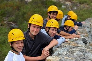 students wearing hard hats preparing for an abseiling activity