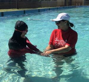 A swim instructor with a Muslim girl in the pool at Lynwood