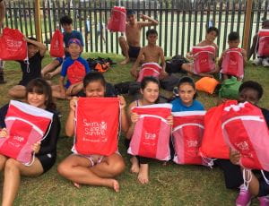 Multicultural students with their red Swim and Survive packs at Lynwood Senior High School