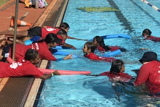 Martu kids practising reach rescues with pool noodles