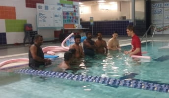 7 men learning to swim with an instructor in the pool at Cannington Leisureplex