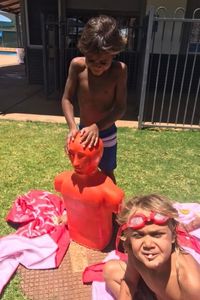 Two Aboriginal boys with a tow mannequin