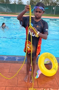 girl at Mt Magnet swimming pool learning about rope throw rescues