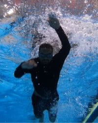 A multicultural man swimming in a pool