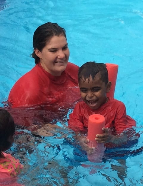 young aboriginal boy in a swimming pool with swim instructor