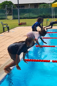 Ngalangangpum students diving into the Warmun pool for a swimming race
