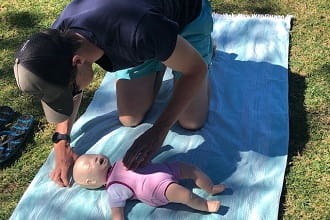 Northshore staff member practising CPR on an infant manikin