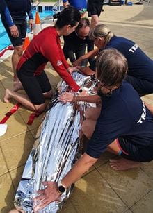 pool lifeguard trainers practising treating hypothermia