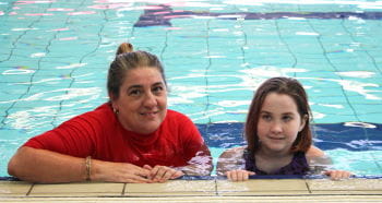 Instructor Cecilia Cappeluti with SAIL participant Sahara Pittaway at the edge of the pool