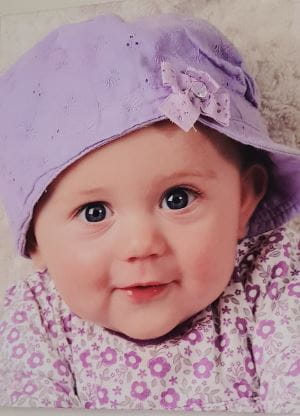 Shelby Wakefield wearing a lilac baby hat and floral dress