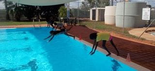 Aboriginal children diving into the pool at Yaneyarra