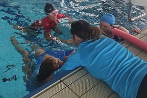 aquatic trainers practising rescue scenarios in a pool