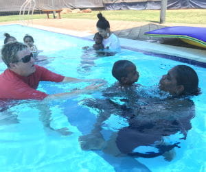 Instructor Adele Caporn with a baby and mum in the pool at Fitzroy Crossing