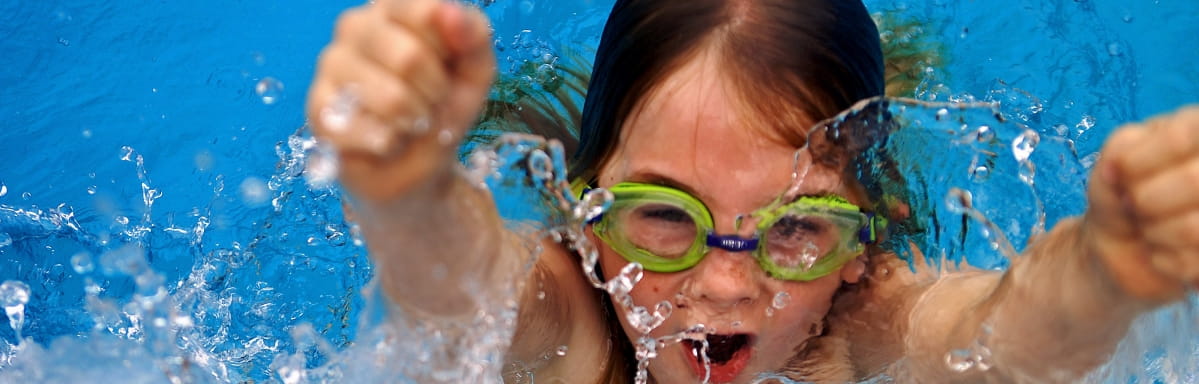 A young girl burst out of a swimming pool