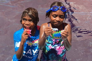 Two Aboriginal children in the pool with pool toys