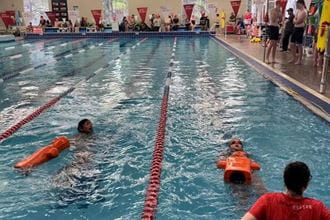 participants completing a manikin tow at a junior lifeguard club carnival event