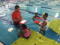 Teacher in the pool with three students