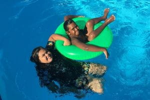 Two Aboriginal girls on an inflatable in the pool