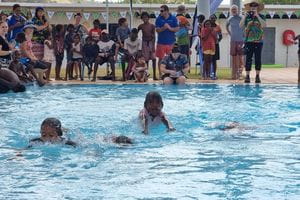 Kids in a swimming race at Warmun Pool
