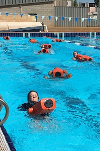 Bronze Medallion participants towing manikins in the water