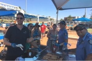 Town of Port Hedland staff and police cooking a sausage sizzle