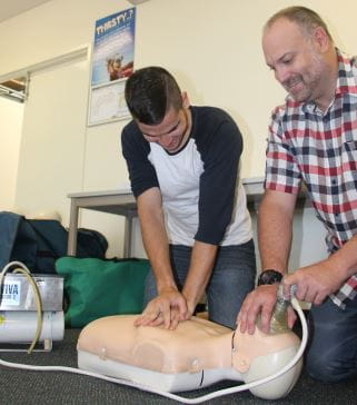 Ty Narkle and Damian Wood practising CPR on a manikin
