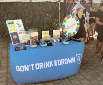 A volunteer at the Don't Drink and Drown stand during O Day