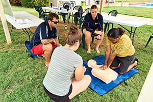group of people practising CPR on a manikin