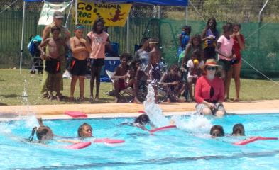 aboriginal children swimming with kickboards at Warmun Pool