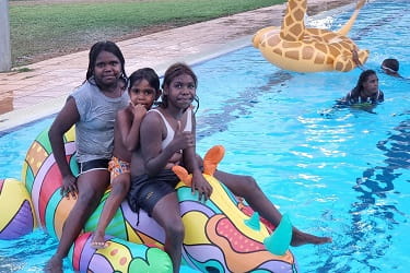 three Aboriginal girls on an inflatable at the Warmun pool