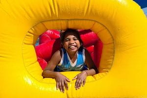 young Aboriginal girl smiling through a giant pool inflatable