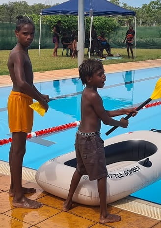 two Aboriginal boys next to an inflatable pool boat