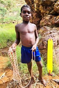 young Aboriginal boy holding a rescue tube