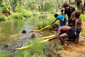 children at a river practising reach rescues