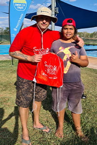 Pool manager giving swim bag to student