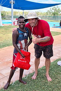 Pool manager giving swim pack to student