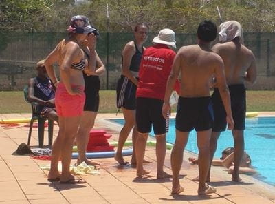 group of students next to a pool at a bronze medallion training course