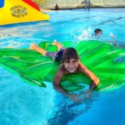 An aboriginal boy on a leaf inflatable in the pool