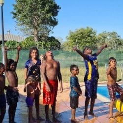 Aboriginal children lining up to go on the pool inflatable