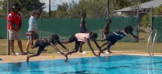 Aboriginal children diving into the pool at Warmun
