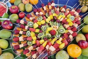 A tray of colourful fruit kebabs