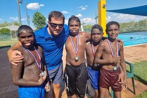 Pool Manager Steven Waterman with a group of Aboriginal boys wearing place medals