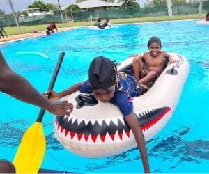 Two Aboriginal boys in an inflatable boat in the pool