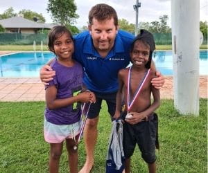 Two children with Pool Manager Stephen Waterman holding their medals