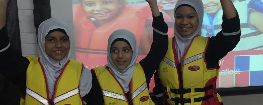 3 Muslim girls wearing lifejackets