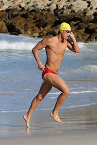 A swimmer running out of the water